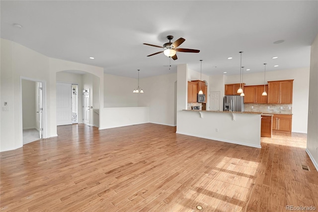 unfurnished living room with light hardwood / wood-style flooring and ceiling fan