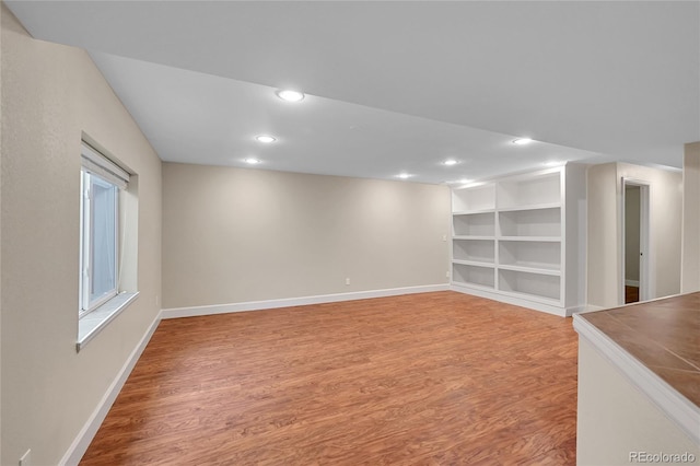 basement with wood-type flooring and built in features