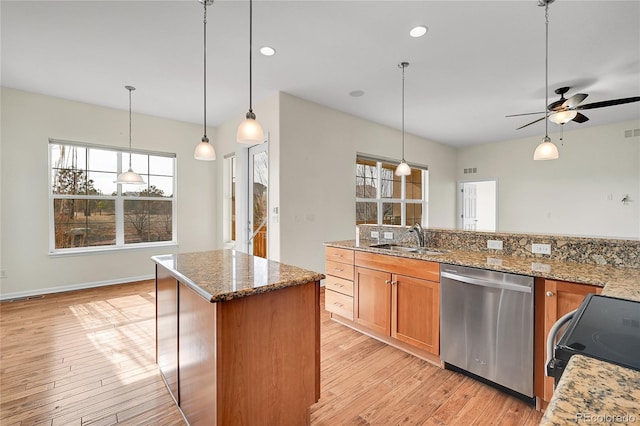 kitchen featuring range with electric stovetop, pendant lighting, dishwasher, sink, and light stone countertops