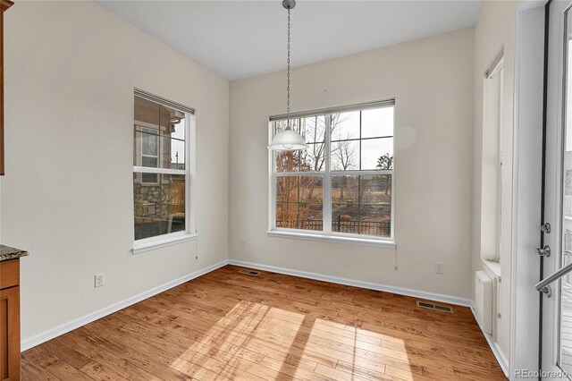 unfurnished dining area with light wood-type flooring