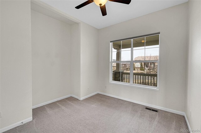 carpeted spare room featuring ceiling fan