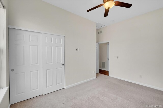 unfurnished bedroom with light carpet, ceiling fan, and a closet