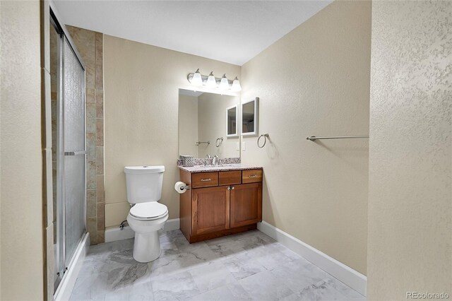 bathroom with vanity, toilet, and a shower with shower door