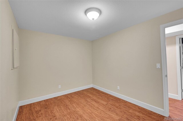 unfurnished room featuring light hardwood / wood-style floors and a textured ceiling