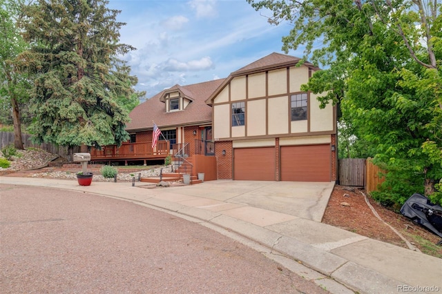 969 Pulpit Rock Ct, Colorado Springs, CO 80918 - tudor home featuring brick siding, driveway, a garage, a deck, and stucco siding