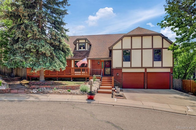 969 Pulpit Rock Ct, Colorado Springs, CO 80918 - tudor house with stucco siding, a garage, driveway, roof with shingles, and brick siding