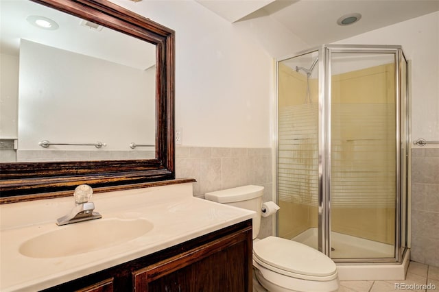 969 Pulpit Rock Ct, Colorado Springs, CO 80918 - bathroom featuring vanity, a stall shower, toilet, tile patterned floors, and tile walls
