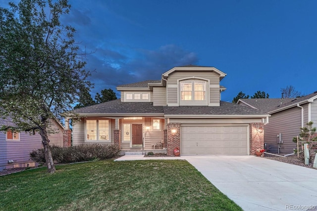 traditional home featuring a front yard, brick siding, a shingled roof, concrete driveway, and an attached garage