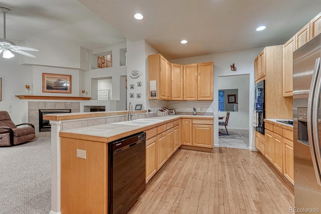 kitchen featuring light brown cabinetry, ceiling fan, a sink, and black appliances