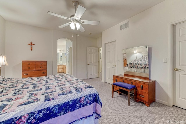 bedroom with visible vents, light carpet, baseboards, ceiling fan, and arched walkways