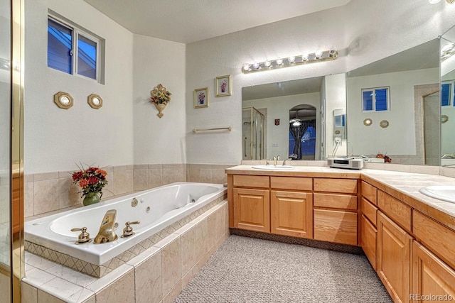 full bathroom with double vanity, a sink, a whirlpool tub, and a shower stall