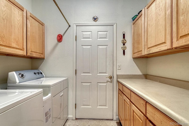 clothes washing area with cabinet space and separate washer and dryer