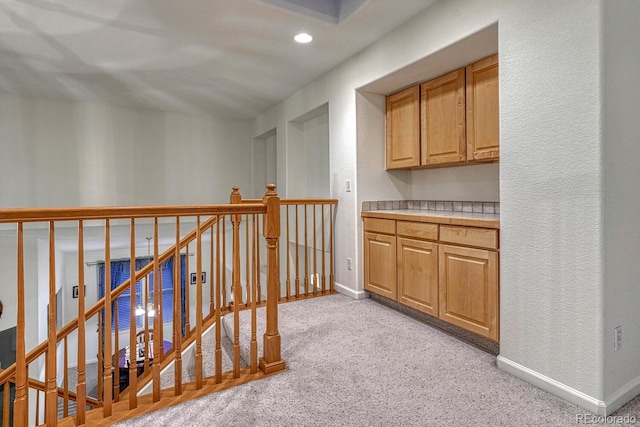 corridor featuring baseboards, recessed lighting, an upstairs landing, and light carpet