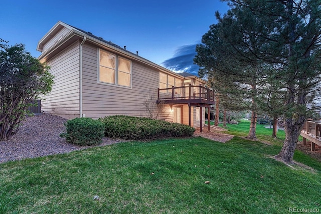 view of side of property with a yard and a wooden deck