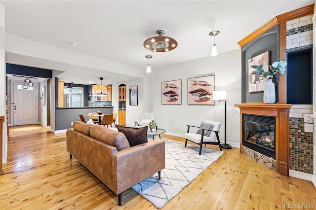 2319 Decatur St, Denver, CO 80211 - living room featuring light wood-style floors, a glass covered fireplace, and arched walkways