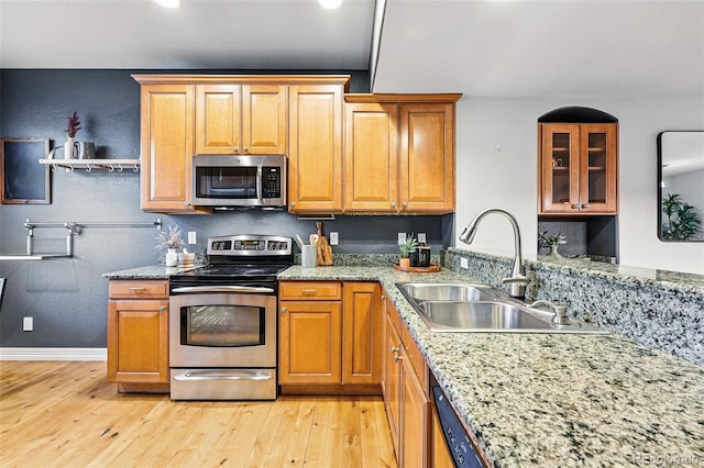 2319 Decatur St, Denver, CO 80211 - kitchen featuring stainless steel appliances, light wood-style floors, light stone counters, glass insert cabinets, and brown cabinetry