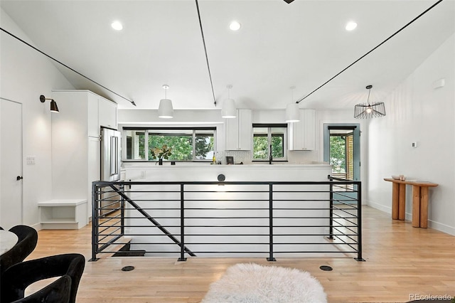 1920 S Niagara St, Denver, CO 80224 - kitchen with white cabinetry, high quality fridge, lofted ceiling, light wood finished floors, and pendant lighting