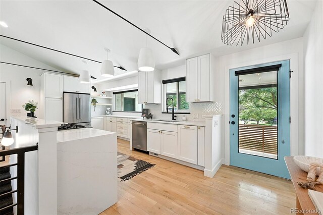 1920 S Niagara St, Denver, CO 80224 - kitchen featuring appliances with stainless steel finishes, white cabinetry, light wood-style flooring, open shelves, and decorative light fixtures