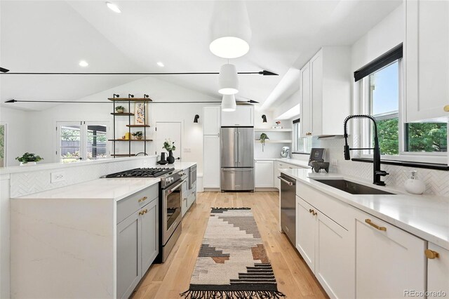 1920 S Niagara St, Denver, CO 80224 - kitchen featuring stainless steel appliances, open shelves, tasteful backsplash, lofted ceiling, and white cabinetry