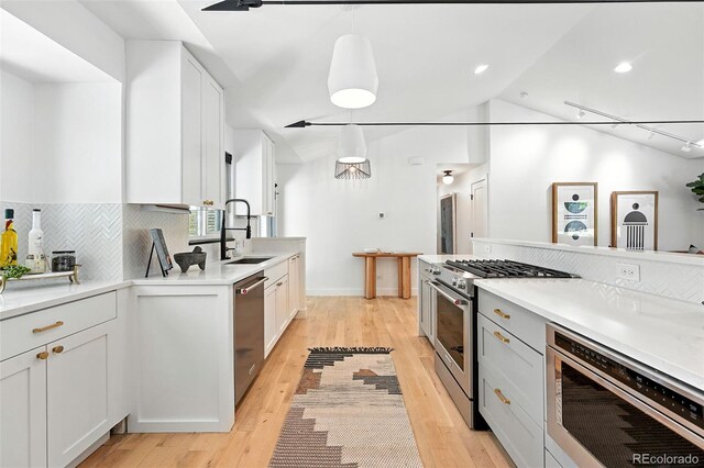 1920 S Niagara St, Denver, CO 80224 - kitchen with appliances with stainless steel finishes, backsplash, light wood-type flooring, light countertops, and vaulted ceiling