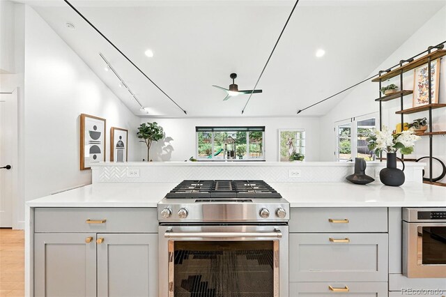 1920 S Niagara St, Denver, CO 80224 - kitchen featuring stainless steel gas range oven, gray cabinetry, vaulted ceiling, light countertops, and recessed lighting
