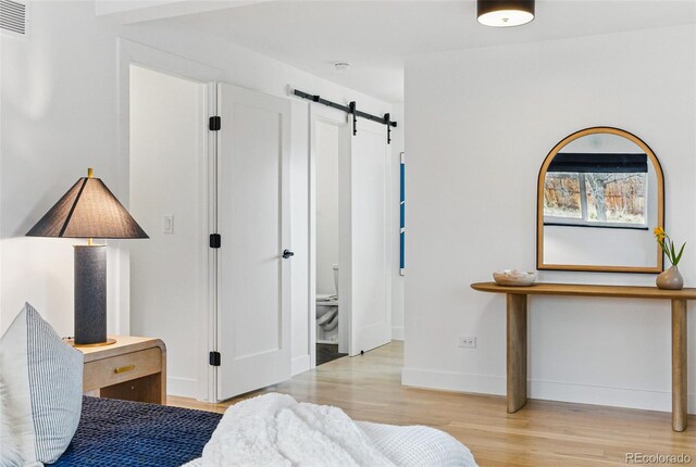 1920 S Niagara St, Denver, CO 80224 - bedroom with a barn door and light wood-style flooring