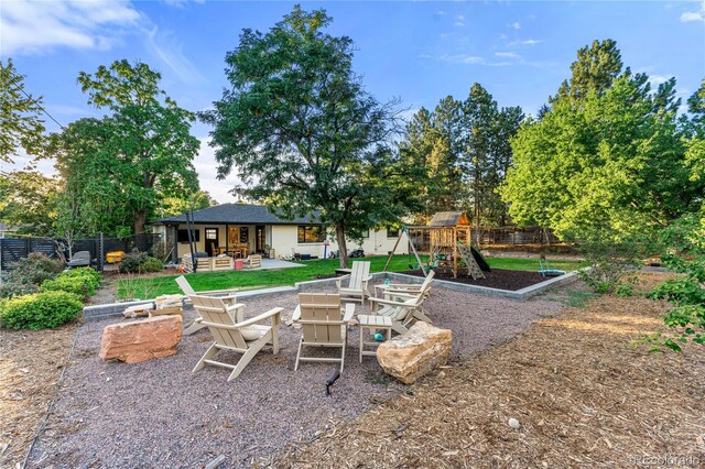 1920 S Niagara St, Denver, CO 80224 - fenced backyard with a playground, a patio area, and a fire pit