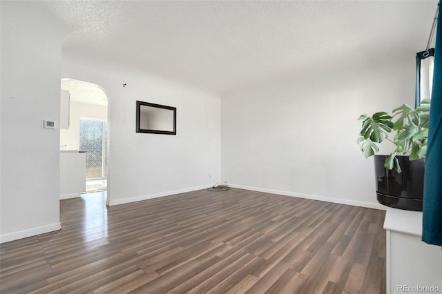 unfurnished living room with dark hardwood / wood-style flooring and a textured ceiling