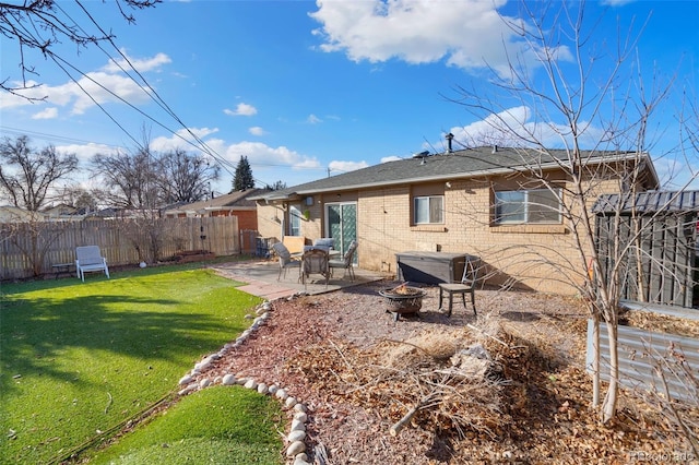 back of house featuring a yard, an outdoor fire pit, and a patio area