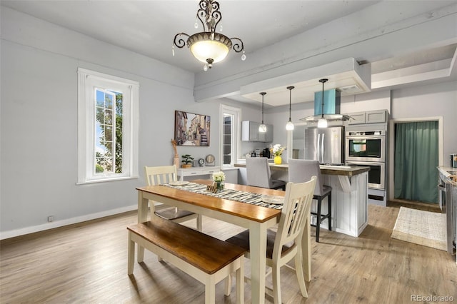 805 5th St, Fort Lupton, CO 80621 - dining space with light wood finished floors and a raised ceiling