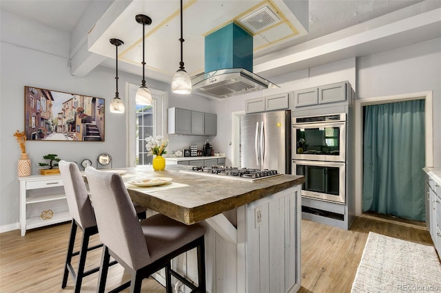 805 5th St, Fort Lupton, CO 80621 - kitchen featuring gray cabinets, appliances with stainless steel finishes, exhaust hood, wooden counters, and light wood finished floors