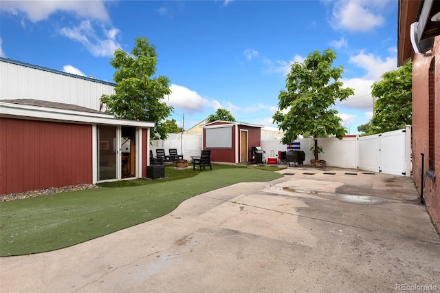 805 5th St, Fort Lupton, CO 80621 - fenced backyard with a patio, a storage unit, and a gate
