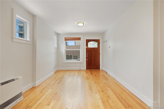 foyer entrance featuring heating unit and light hardwood / wood-style floors