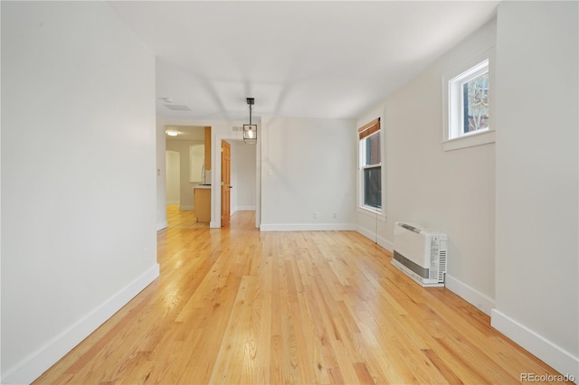 empty room featuring light hardwood / wood-style floors and heating unit