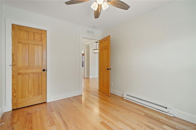 unfurnished bedroom with ceiling fan, light hardwood / wood-style flooring, and a baseboard heating unit