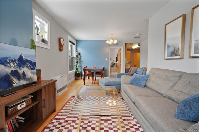 living room featuring a notable chandelier and light hardwood / wood-style flooring