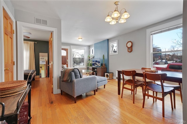 living room with a notable chandelier and light wood-type flooring