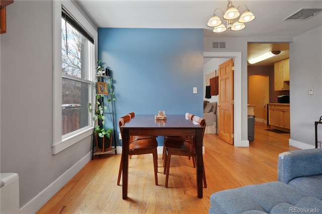 dining area with a notable chandelier and light wood-type flooring