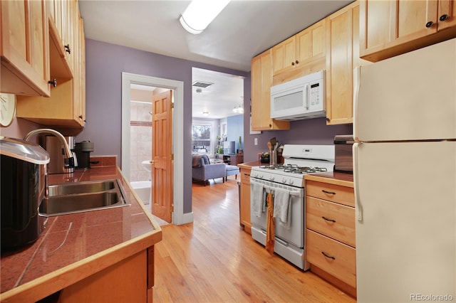 kitchen with white appliances, light hardwood / wood-style floors, sink, and light brown cabinets