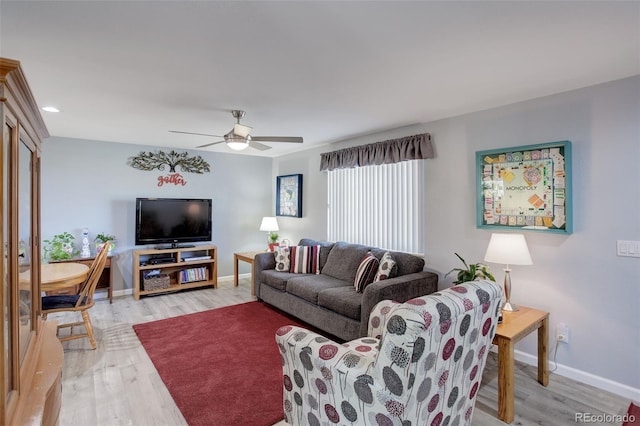 living room with ceiling fan and light hardwood / wood-style flooring