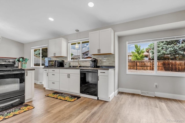 6441 W 73rd Pl, Arvada, CO 80003 - kitchen with black appliances, light wood-type flooring, dark countertops, healthy amount of natural light, and recessed lighting