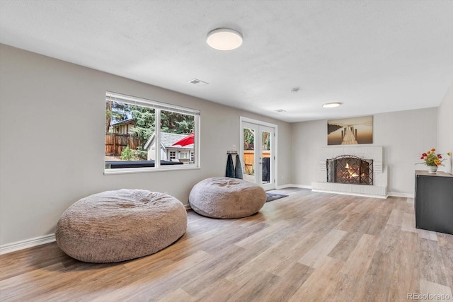 6441 W 73rd Pl, Arvada, CO 80003 - sitting room with wood finished floors, a brick fireplace, and french doors
