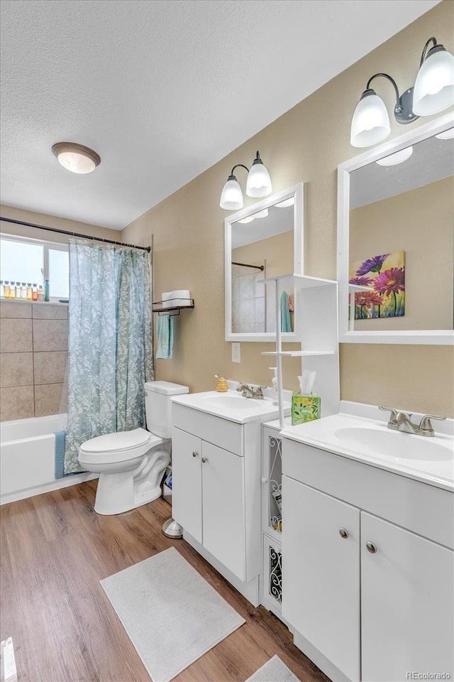 6441 W 73rd Pl, Arvada, CO 80003 - bathroom with two vanities, wood finished floors, a textured ceiling, and shower / bath combo