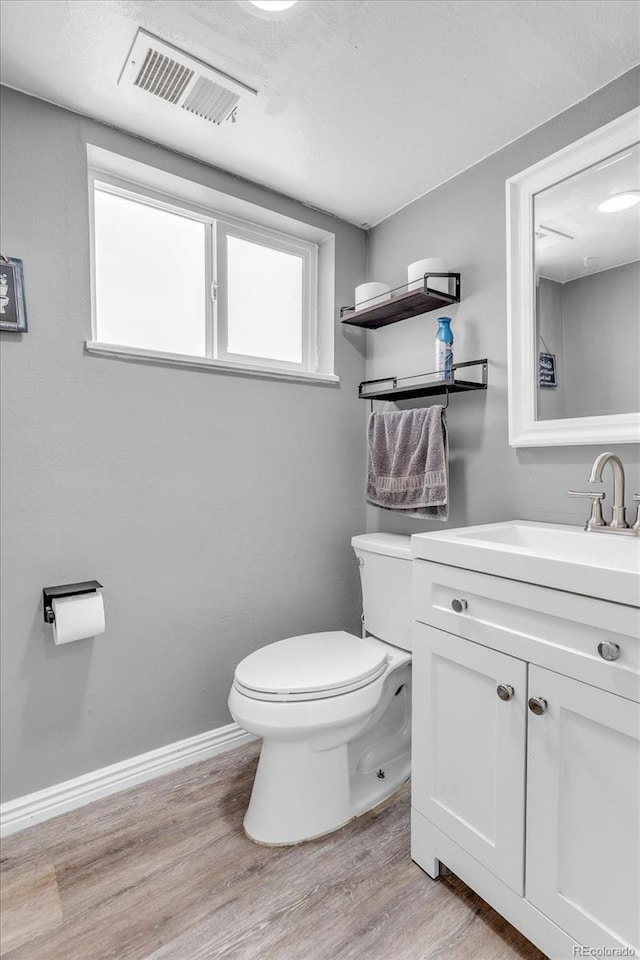 6441 W 73rd Pl, Arvada, CO 80003 - half bathroom featuring vanity and wood finished floors
