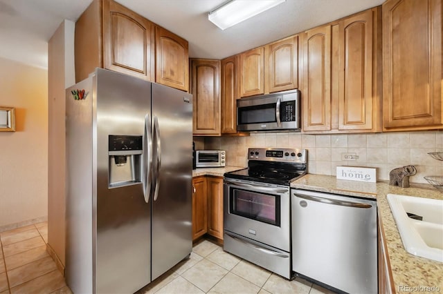 715 S Alton Way Unit 5D, Denver, CO 80247 - kitchen featuring appliances with stainless steel finishes, light tile patterned floors, and backsplash