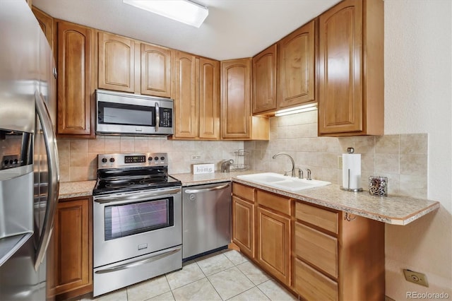 715 S Alton Way Unit 5D, Denver, CO 80247 - kitchen featuring appliances with stainless steel finishes, a sink, decorative backsplash, light tile patterned floors, and brown cabinetry