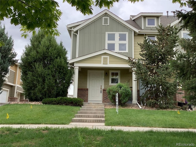 11947 Riverstone Cir Unit 7F, Henderson, CO 80640 - view of front facade featuring board and batten siding, a front yard, and brick siding