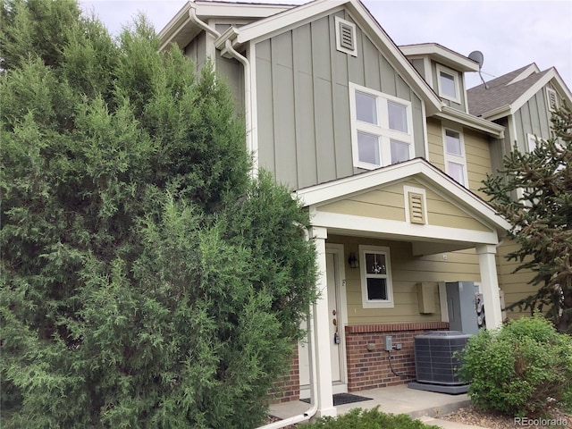 11947 Riverstone Cir Unit 7F, Henderson, CO 80640 - view of front of home featuring board and batten siding, central air condition unit, and brick siding