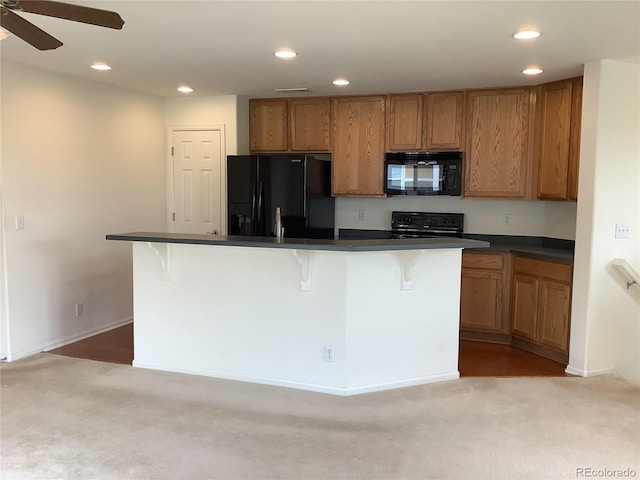 11947 Riverstone Cir Unit 7F, Henderson, CO 80640 - kitchen with black appliances, dark countertops, carpet floors, recessed lighting, and brown cabinets