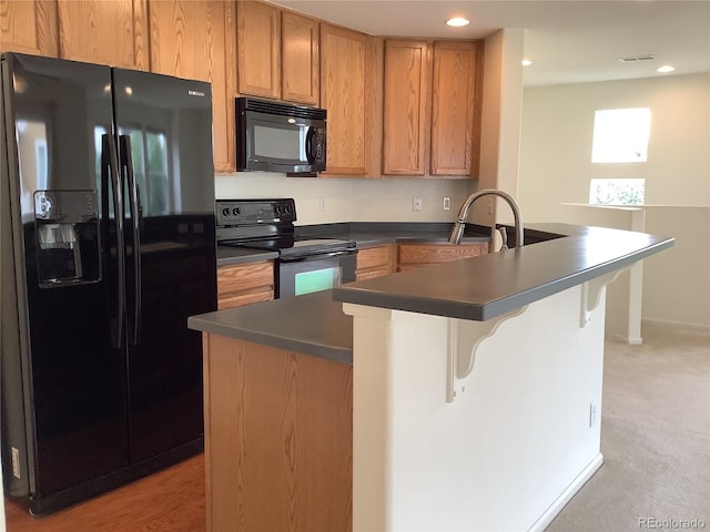 11947 Riverstone Cir Unit 7F, Henderson, CO 80640 - kitchen featuring black appliances, dark countertops, a breakfast bar area, a peninsula, and recessed lighting